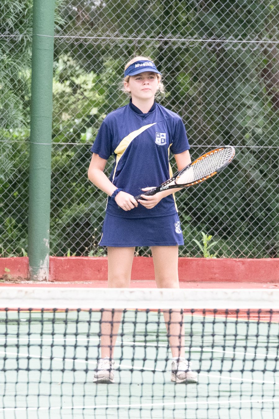 A pupil waiting to serve on the tennis court